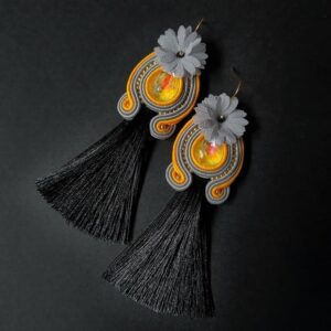 Un paio di orecchini artigianali donna, con nappe, cristalli e fiori. Orecchini lunghi, neri, con cristallo giallo.